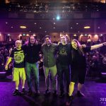 Entransient band members pose on stage for a photo with the audience