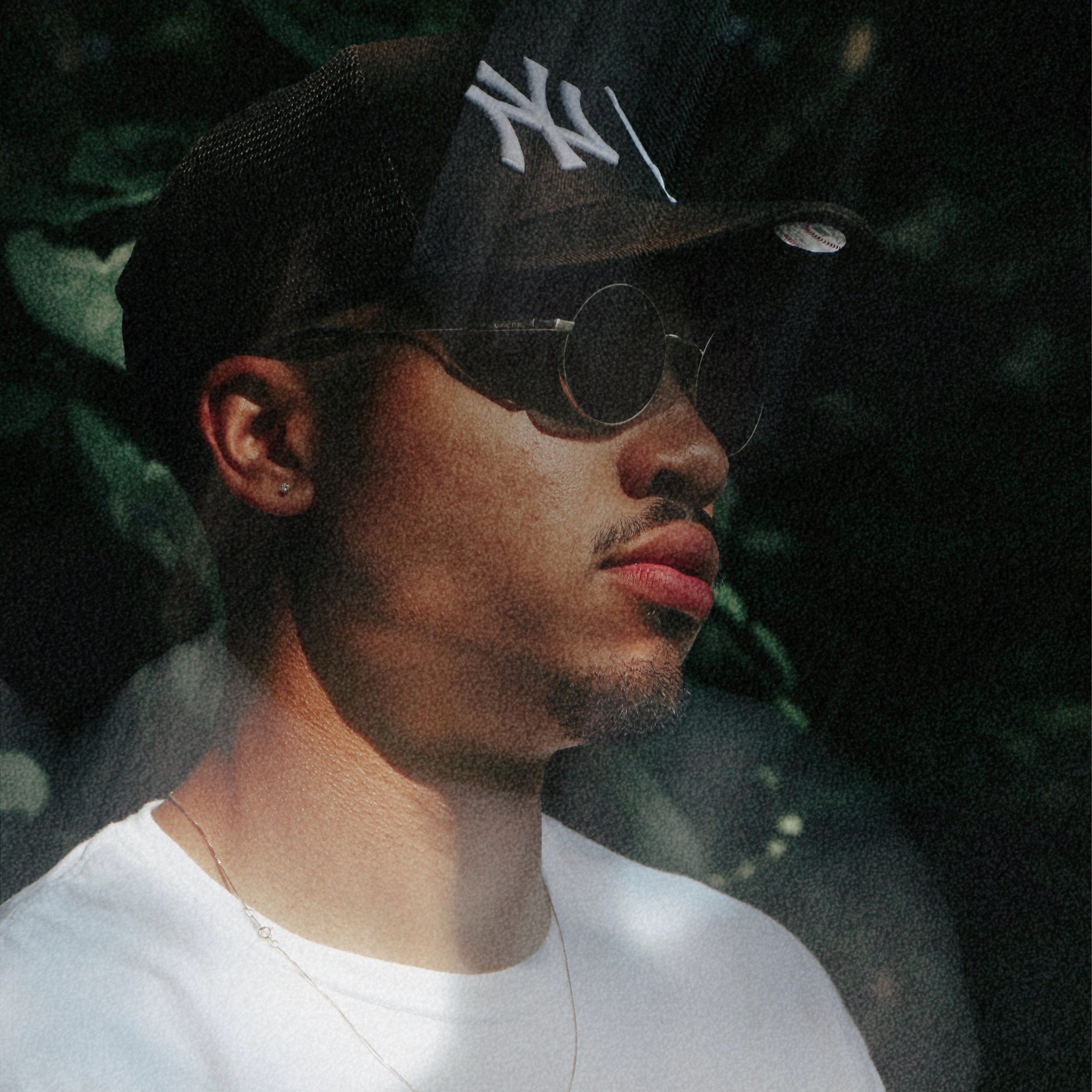 Brandon Rose is pictured wearing a New York Yankees ball cap and round sun glasses