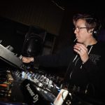 DJ Whitney Who is shown at a DJ table