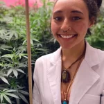 Ganja Girl poses next to some ganja plants