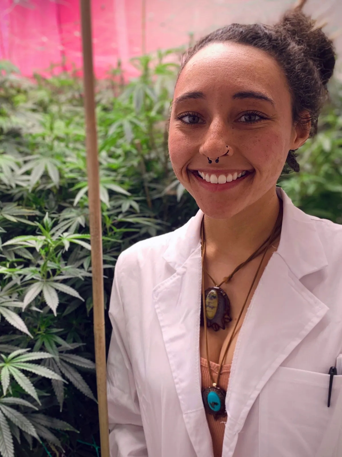 Ganja Girl poses next to some ganja plants