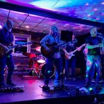 The band is pictured on stage.