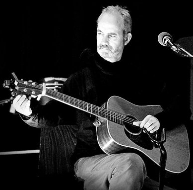 O'Shea plays guitar in a black and white image