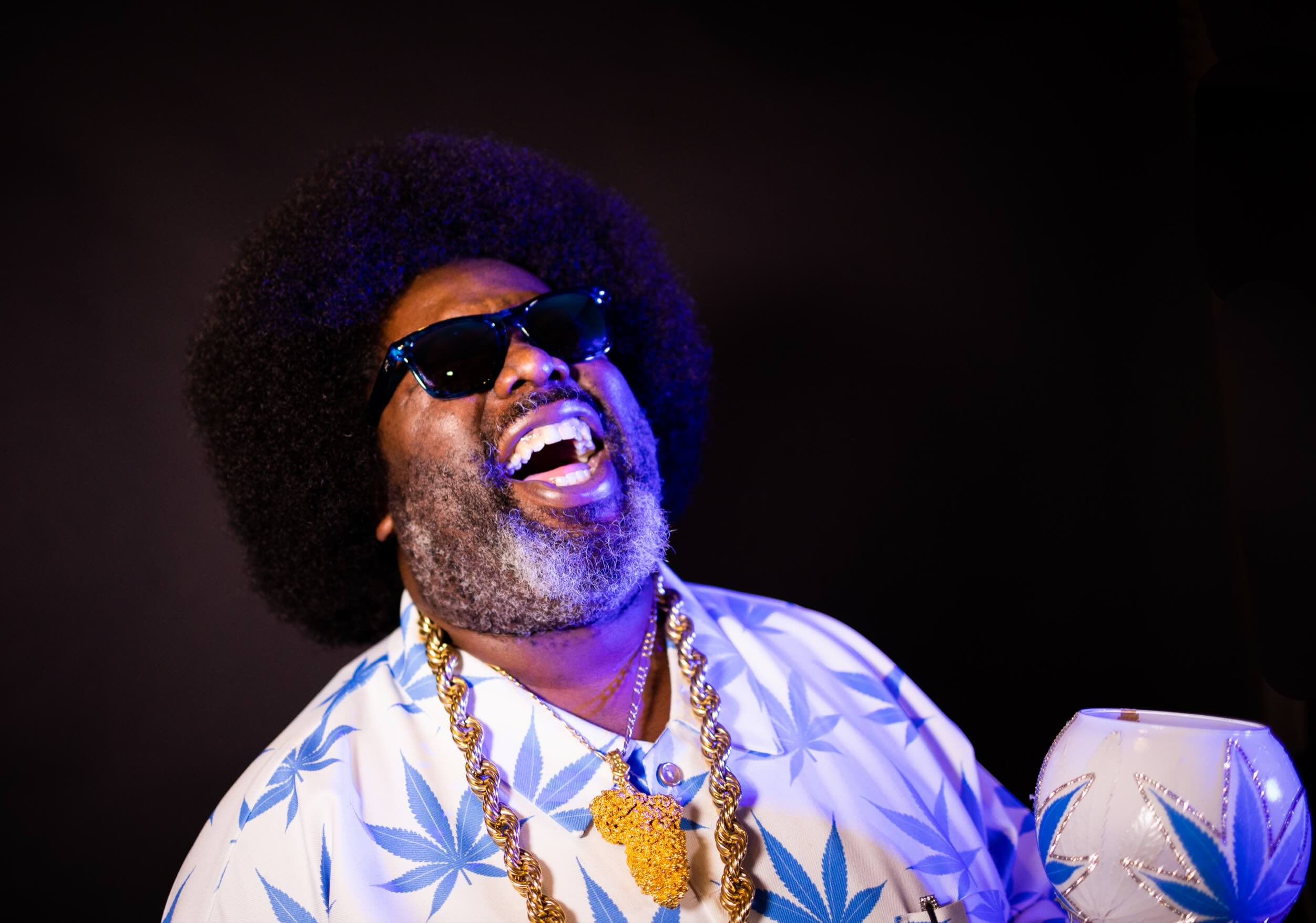 Afroman is pictured wearing a shirt with weed leaves and holding a matching goblet.