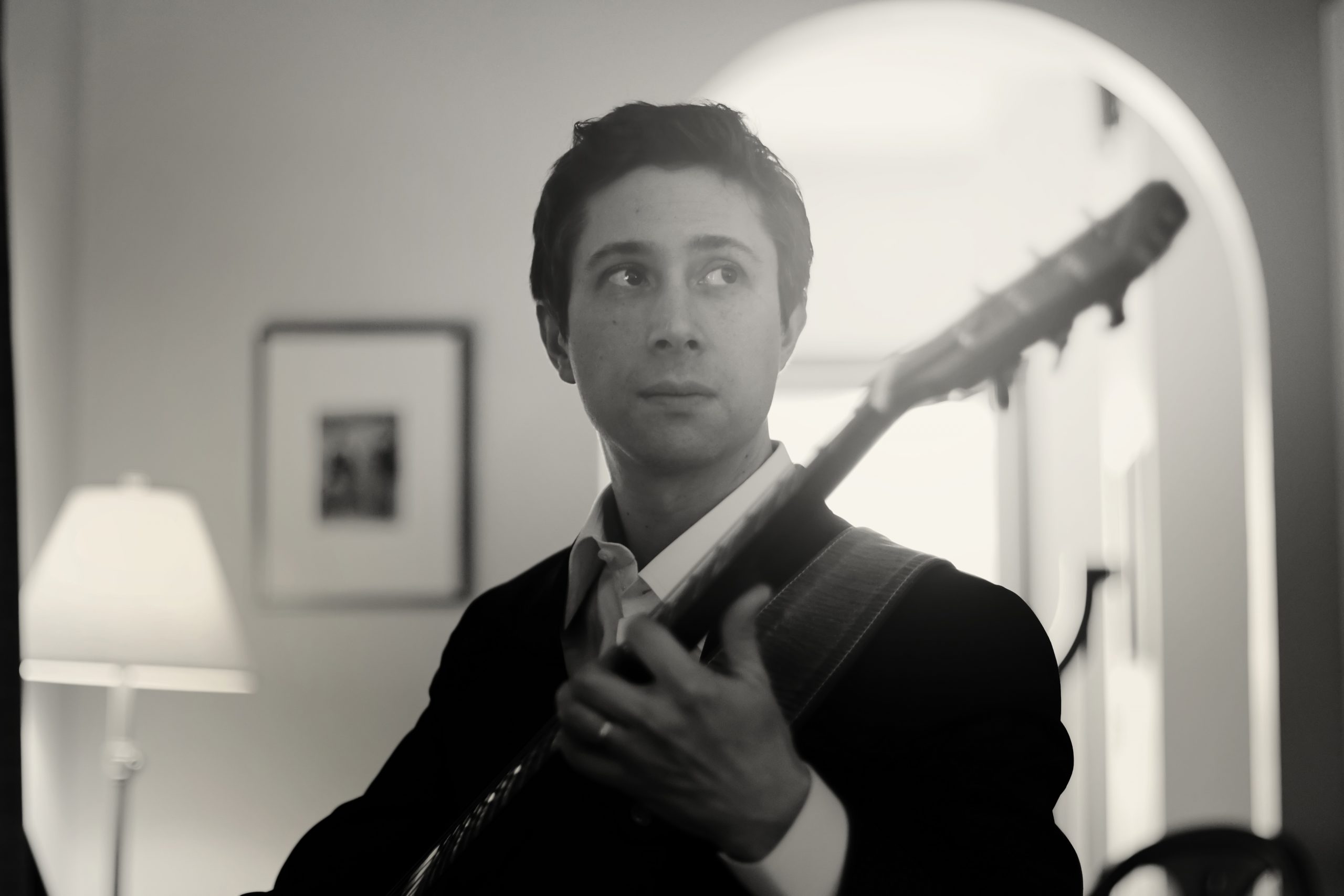 Napoleon pictured in a living room playing his guitar